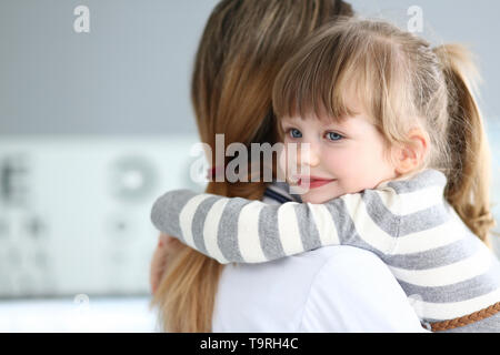 Cute little girl hugging woman portrait dans son bureau Banque D'Images