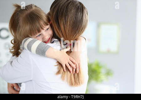 Cute little girl hugging woman portrait dans son bureau Banque D'Images