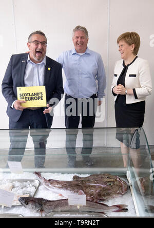 Premier ministre Nicola Sturgeon avec des candidats à l'élection européenne SNP Christian Allard (à gauche) et Andrew Charles propriétaire lors d'une visite à J Charles Ltd usine de transformation de fruits de mer à Aberdeen. Christian Allard a travaillé à J Charles Ltd pour 25 ans l'exportation de fruits de mer sur le continent, avant d'entrer en politique. Banque D'Images