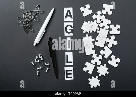 Mot AGILE, morceaux de puzzle et de papeterie sur fond sombre Banque D'Images