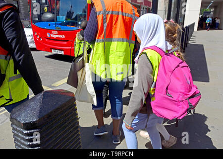 Londres, Angleterre, Royaume-Uni. Les écoliers, attendant d'être sur un bus - jeune fille portant un foulard Banque D'Images