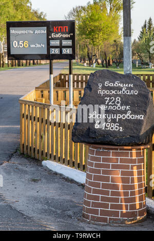 Chojniki, Bélarus, - le 26 avril 2019 : signer avec radio réelle du niveau d'activité et pierre commémorative à l'entrée de la zone d'exclusion de Tchernobyl Banque D'Images