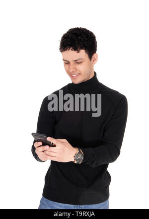 Un close up image of a smiling young man est heureux sur le message qu'il reçoit sur son téléphone cellulaire, isolée pour fond blanc Banque D'Images
