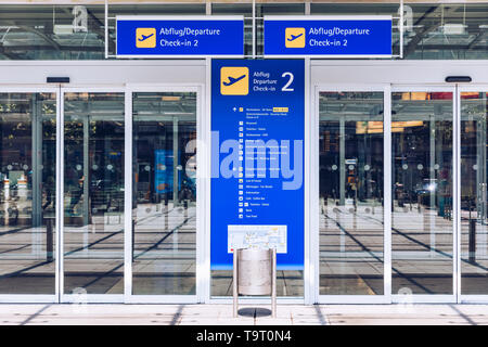 Terminal de l'aéroport d'entrée automatique et construire la porte porte en verre avec texte d'information en allemand et en anglais. L'aéroport moderne mur de verre de la fenêtre et de la porte de l'allée Banque D'Images