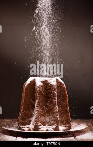 Avec Pandoro saupoudrage de sucre glace sur fond brun. Close up Banque D'Images