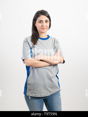 Jeune fille vierge portant des T-shirt gris et un jean bleu. Fond de mur gris . Banque D'Images