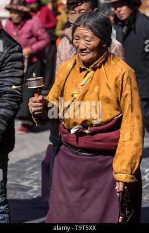 Une vieille femme circumambulates pèlerin tibétain le Temple de Jokhang, avec son chapelet de mala et prières à Lhassa, au Tibet. Banque D'Images