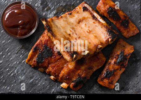 Côtes levées barbecue grillé sur l'ardoise noire. Banque D'Images