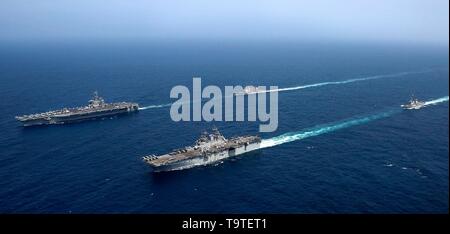 La Marine américaine de classe Nimitz porte-avions USS Abraham Lincoln, à gauche, mène des opérations conjointes avec l'USS Kearsarge, navire d'assaut amphibie, le 17 mai 2019 dans la mer d'Oman. Le groupe fait partie des forces additionnelles d'être envoyé au Moyen Orient pour lutter contre ce que l'administration d'Atout appelle des indications claires de menaces de l'Iran. Banque D'Images