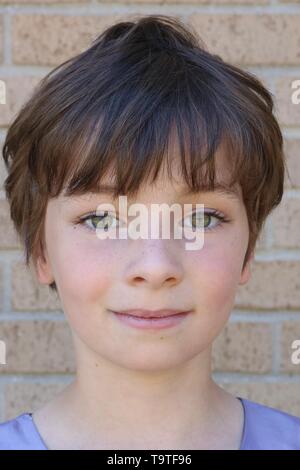 Portrait d'un enfant avec une coupe pixie marron et de grands yeux noisettes Banque D'Images