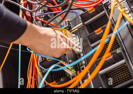 Technicien mâle de brancher le câble réseau Fibre Channel dans Blade Server Banque D'Images