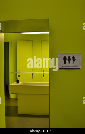 La signalisation des toilettes toutes sortes à côté d'une porte de la salle de bains en vert acide avec des icônes de l'homme, de la femme, les transgenres. Icônes noires sur un fond blanc Banque D'Images