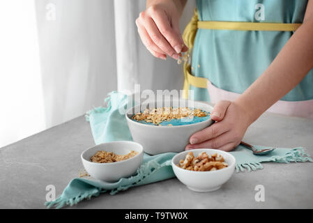 Femme préparant de délicieux muesli in kitchen Banque D'Images