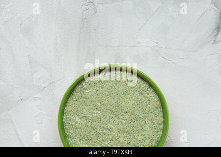 Thé vert matcha semences chia pudding bol. Fermer le haut, vue, télévision lay. Superfood et végétaliens concept. Fond gris. Banque D'Images