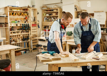 Portrait de deux charpentiers travaillant avec du bois debout au tableau de l'atelier, copy space Banque D'Images