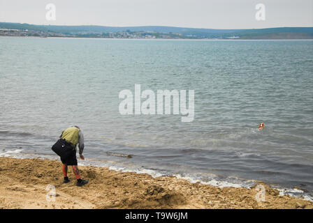 Weymouth. 20 mai 2019. Un homme joue 'fetch' avec son chien sous un ciel couvert mais jour doux à Weymouth. crédit : Stuart fretwell/Alamy Live News Banque D'Images