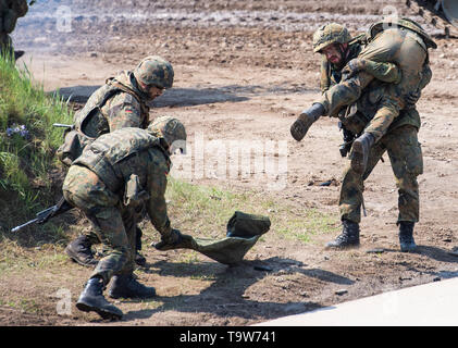 Munster, Allemagne. 20 mai, 2019. Au cours d'une manifestation de très haut degré de disponibilité de l'Équipe spéciale mixte (VJTF), un soldat blessé est porté par un autre soldat. En 2019, l'Allemagne sera responsable de la force de réaction rapide de l'OTAN. Credit : Christophe Gateau/dpa/Alamy Live News Banque D'Images