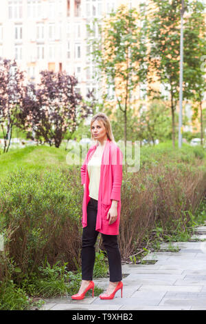 Portrait de jeune femme sérieuse belle réussite dans le style élégance debout sur Green Park, posant avec un visage confiant et regarder Banque D'Images