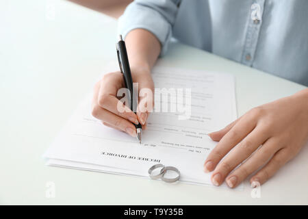 Jeune femme signature jugement de divorce à table, gros plan Banque D'Images