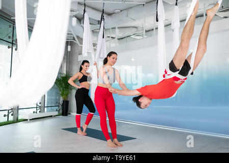 Homme actif portant des T-shirt d'essayer le yoga de l'antenne pour la première fois Banque D'Images
