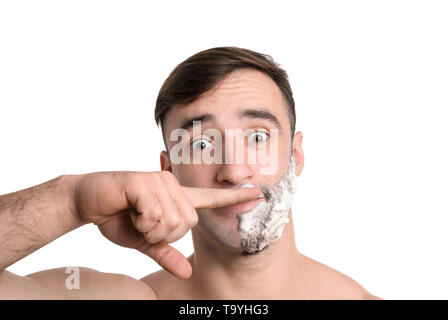 L'homme drôle avec mousse à raser sur son visage contre fond blanc Banque D'Images