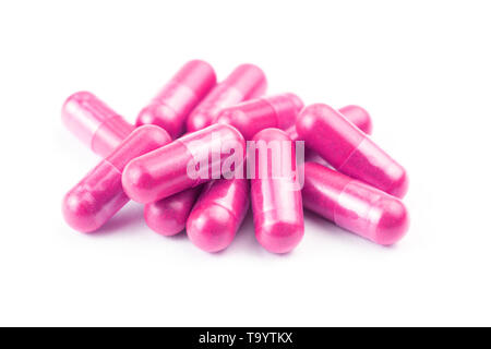 Pile de capsules bio rose isolé sur fond blanc libre avec focus sélectif. Banque D'Images