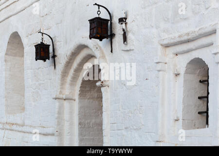 lampadaires en fer forgé sur un mur de briques en stuc blanc avec des fenêtres en voûte Banque D'Images