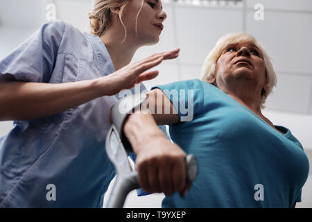 Low angle d'une triste femme âgée à l'aide de béquilles Banque D'Images