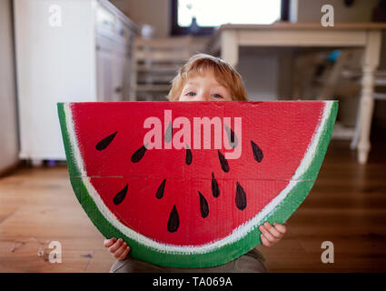 Un bébé Garçon jouant avec grand jouet à l'intérieur de fruits à la maison, manger des fruits concept. Banque D'Images