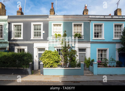 La traditionnels colorés des maisons mitoyennes avec jardins et portes en bois le long d'une chaussée de pierre le long d'une journée d'automne. Londres. UK. Banque D'Images