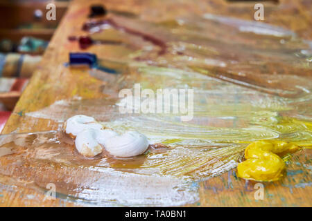 Image créative, la palette d'artiste avec des peintures à l'huile et des pinceaux, close-up, palette en bois, peint de couleurs différentes Banque D'Images