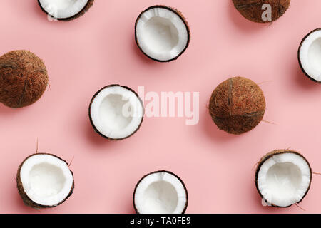 Avec motif sur coco mûre fond rose. Vue d'en haut. Copier l'espace. Pop art design, creative concept d'été. La moitié de la noix de coco dans un minimum de mise à plat Banque D'Images