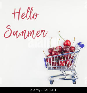 Image carrée de cerises mûres dans un panier avec Hello summer texte sur fond blanc dans un style minimaliste. Concept de supermarché ou fruits du marché s Banque D'Images