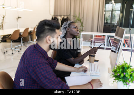 Équipe réussi : business man and woman sitting at desk parle de rapports et de finances. Banque D'Images