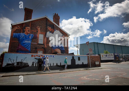 Les gens en passant devant une peinture murale de l'artiste Paul Curtis sur un pignon de la fin d'une maison à Wirral Prenton, représentant deux joueurs de Tranmere Rovers. La murale est situé juste à l'extérieur du stade du club, Prenton Park. Tranmere Rovers acquise à la promotion de la Ligue 2 à partir de l'EFL Ligue nationale via un play-off dans la saison 2017-8 et est retourné à Wembley 12 mois plus tard le 25 mai pour faire face à Newport County pour une place dans une ligue étrangère. Banque D'Images