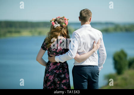 Girl and boy hugging sur une rive de la rivière un jour d'été Banque D'Images