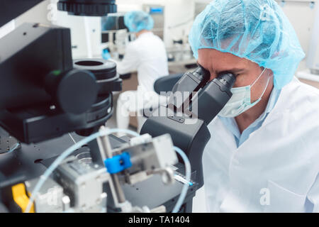 Médecin ou scientifique à la recherche en laboratoire microscope thru Banque D'Images