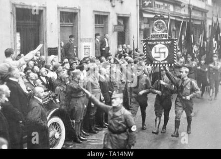 Sur la première conférence des parties de la NSDAP à Weimar, l'appel de Dietrich Eckarts, « Deutschland erwache" (Allemagne éveillé), devient le slogan de la partie encore jeune. Adolf Hitler salue l'étendard de sa voiture, devant se tenir le chef de Franconie Julius Streicher, Gottfried Feder et Alfred Rosenberg. Banque D'Images