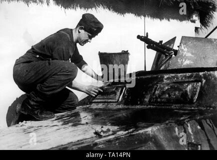 Dans la ville russe de Proletarsk, un soldat supprime la couleur d'un blanc d'hiver Schuetzenpanzer (véhicules blindés). Photo de l'entreprise de propagande (PK) : correspondant de guerre Hitlner. Banque D'Images