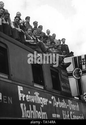 Vue d'un groupe de volontaires de l'Stahlhelm sur une troupe de la Deutsche Reichsbahn (German National Railway) avec une voiture-lits et une cuisine, qui est stationné à la gare de marchandises de Berlin Koepenick. Sur la droite, l'ancien drapeau impérial de guerre de l'Empire allemand. Banque D'Images
