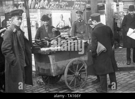 Dans une rue de Berlin le stand d'un vendeur de saucisses est gardée par l'armée. En face de la tribune sont les passants à la recherche sur le stand. Derrière la position sur une carte sont des affiches avec des appels de l'assemblée. Ci-dessus le stand stands : Prima du sang de bouc et le foie 3,00 Saucisse saucisse chaude M. 90, - et 1,00.' Banque D'Images