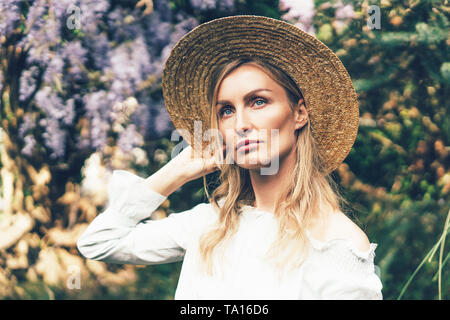 Triste caucasian woman in Straw Hat dans le parc au printemps. Banque D'Images