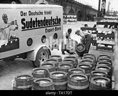 Deux hommes décharger un camion de livraison de bière avec un Urbrau «Egerer' le 7 octobre 1938 à Berlin Postdamer Bahnhof après l'occupation des Sudètes par l'Allemagne. Sur le camion : "Les Allemands des Sudètes boissons bières d'exportation allemande. Urbrau Egerer. Grosspriesener Urbrau. Saazer Urstoff. ' Banque D'Images