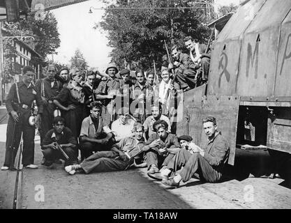 Photo d'un groupe de miliciens du Front Populaire (Frente Popular ) qui combattent aux côtés de la Seconde République Espagnole. Les combattants posent à 15 kilomètres au sud de la capitale de l'Espagne armés de fusils à côté d'une voiture blindée, sur lequel un marteau et la faucille sont peints. L'officier de milice dans la partie inférieure gauche est armé avec un levier Winchester-action gun. Banque D'Images