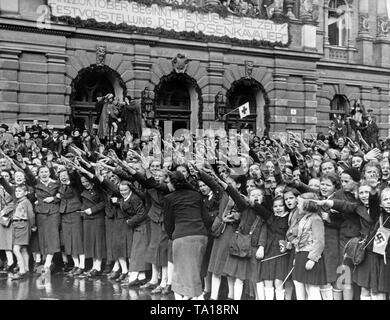 La population de Reichenberg (aujourd'hui Liberec) Bienvenue à la marche des troupes en face du théâtre de la ville le 9 octobre, 1938. Au-dessus de l'entrée du théâtre, un panneau avec l'inscription : "La nouvelle saison commence le 22 octobre ! Gala "Der Rosenkavalier". Banque D'Images