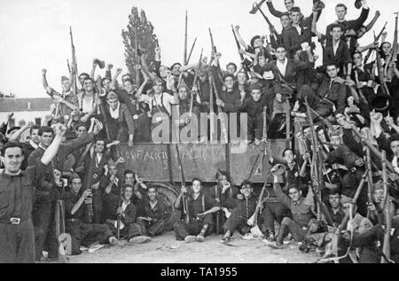 Photo d'un groupe d'encouragement de combattants républicains, vraisemblablement (anarchiste FAI, CNT) volontaires en salopette bleue en face d'un camion. Les combattants sont armés de fusils et de porter des chaussures simples, pour la plupart, d'alpargatas coton simple chaussures avec semelles de chanvre tressé. Sur les planches du chariot : 'A los Fascistas" (contre les fascistes). Banque D'Images