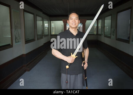 (190521) -- LONGQUAN, 21 mai 2019 (Xinhua) -- Zheng Guorong pose pour une photo avec une épée qu'il a faite à l'Épée 8090 Studio dans l'est de la Chine, Longquan Zhejiang Province, le 21 mai 2019. Pendant des siècles, Longquan a été célèbre pour son épée. Zheng Guorong, 55, un patrimoine culturel immatériel de l'héritière dans Longquan sabre, épée a fait depuis plus de 30 ans. Zheng ce qui concerne l'épée comme un symbole de l'esprit et consacre toute sa carrière avec admiration. Dans son studio, l'ensemble du processus de décisions d'une seule épée prend de deux à trois mois, avec des étapes suivantes, y compris la formation d'une idée, designin Banque D'Images