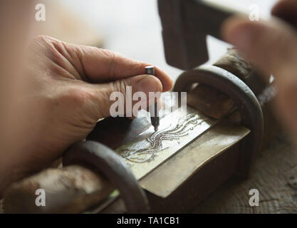 (190521) -- LONGQUAN, 21 mai 2019 (Xinhua) -- Zheng Guorong sculpte patten d'un phénix sur l'Épée Épée en 8090 au studio de l'est de la Chine, Longquan Zhejiang Province, le 21 mai 2019. Pendant des siècles, Longquan a été célèbre pour son épée. Zheng Guorong, 55, un patrimoine culturel immatériel de l'héritière dans Longquan sabre, épée a fait depuis plus de 30 ans. Zheng ce qui concerne l'épée comme un symbole de l'esprit et consacre toute sa carrière avec admiration. Dans son studio, l'ensemble du processus de décisions d'une seule épée prend de deux à trois mois, avec des étapes suivantes, y compris la formation d'une idée, de la conception Banque D'Images