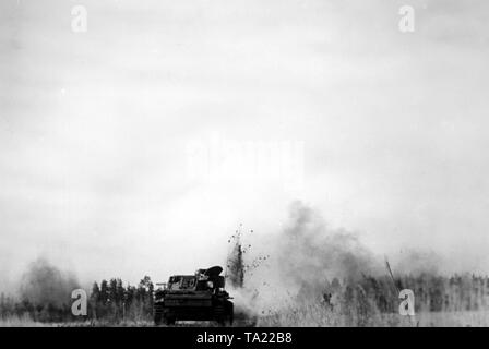 Un char de combat allemand dans un champ au sud-est du lac Ilmen. À côté, l'attaque de l'artillerie soviétique. Photo de l'entreprise de propagande (PK) : SS correspondant de guerre Koerbisser. Banque D'Images