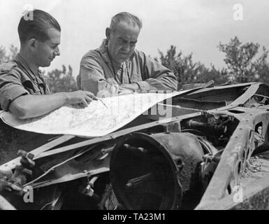 Photo de deux agents de terrain national espagnol en tunique tout en étudiant une carte à un poste de commandement sur le front de l'Ebre à l'été 1938. Un châssis sert de table à cartes. Banque D'Images